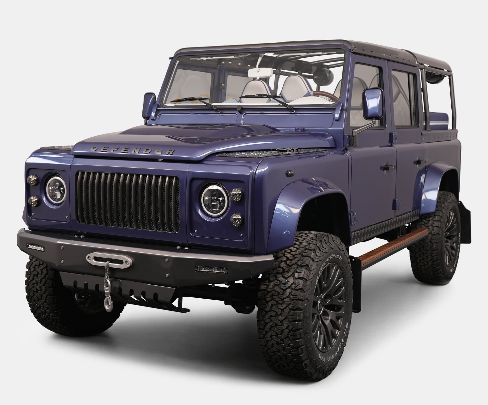 Custom Land Rover Defender in striking blue color with rugged tires and modern design features