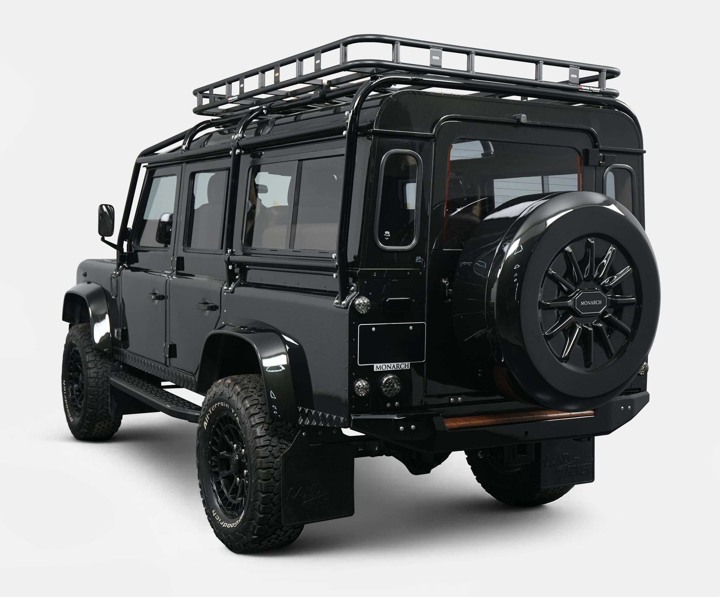 Black custom Land Rover Defender with roof rack and stylish rear design