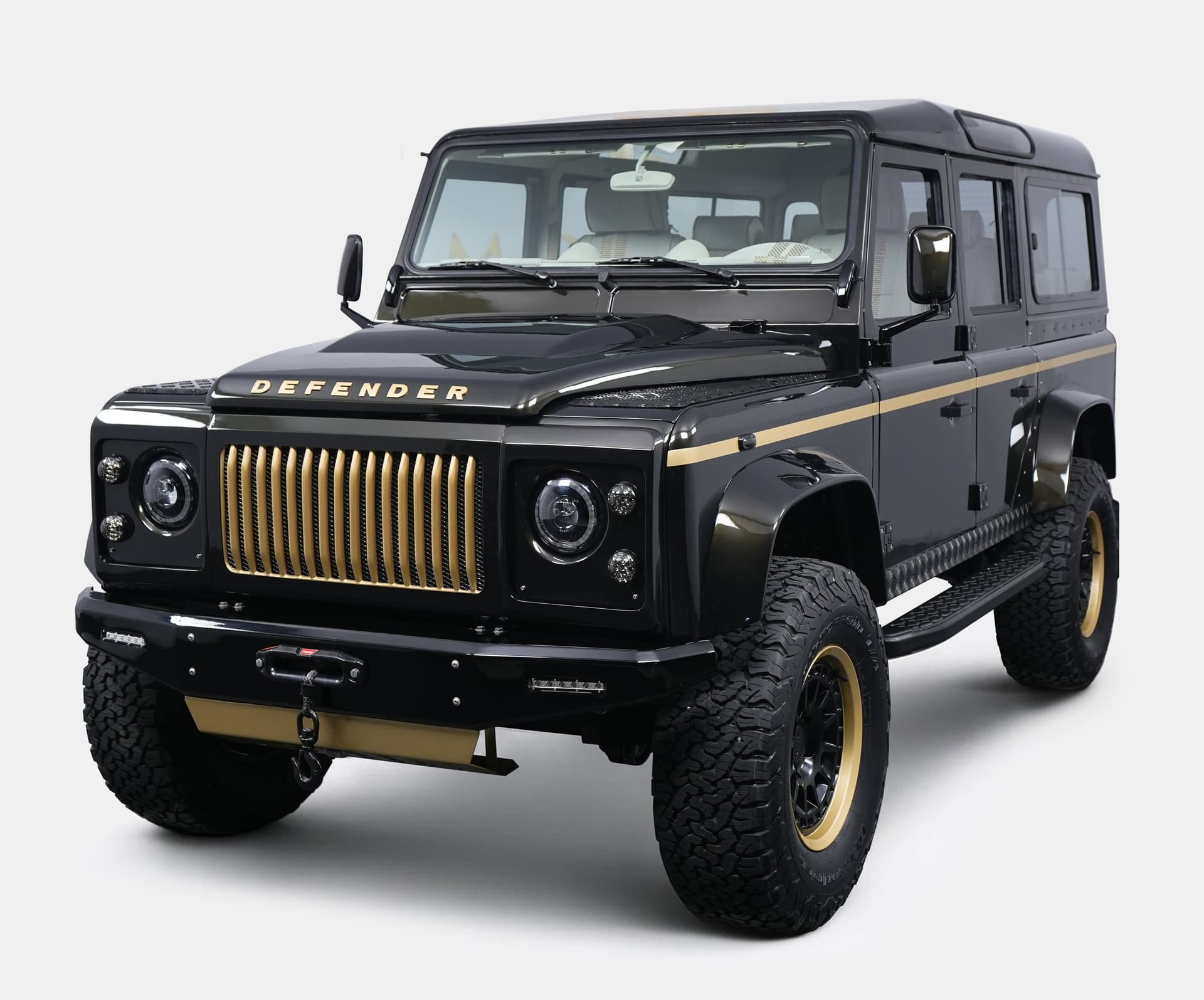 Custom black Land Rover Defender with gold accents and bold grille