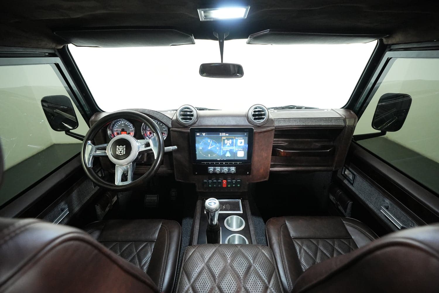 Interior view of a custom Land Rover Defender showcasing premium leather seats and advanced dashboard features