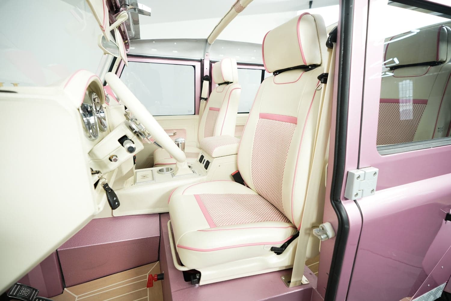 Interior of a bespoke Land Rover Defender with cream and pink leather seats