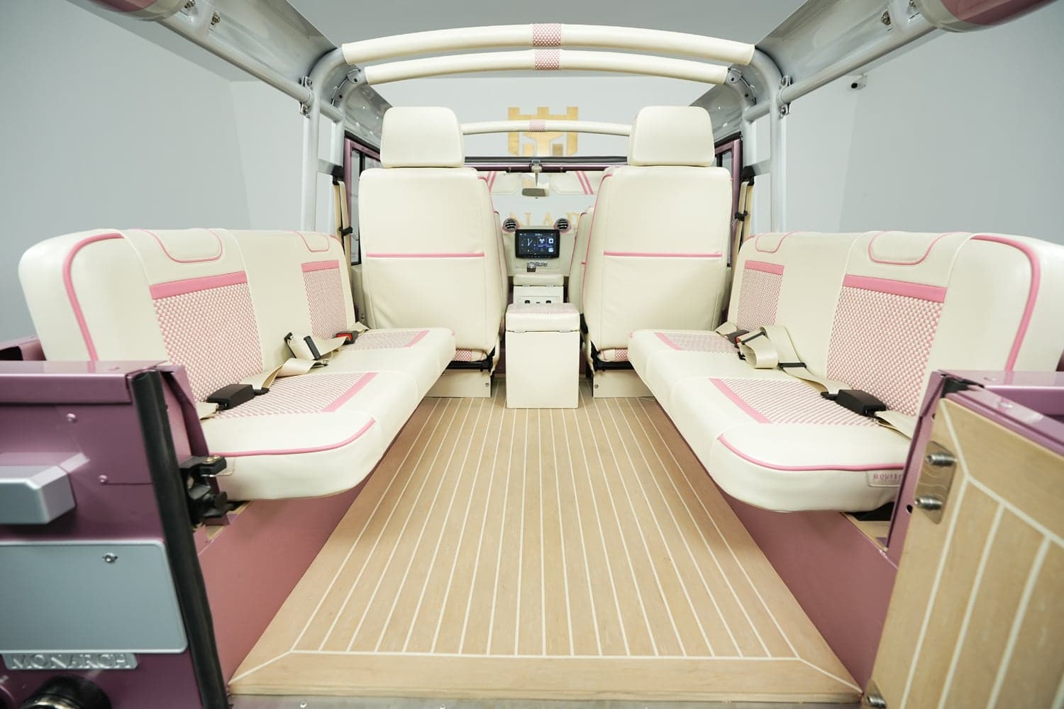 Bespoke interior of a luxury Land Rover Defender featuring cream and pink leather seats