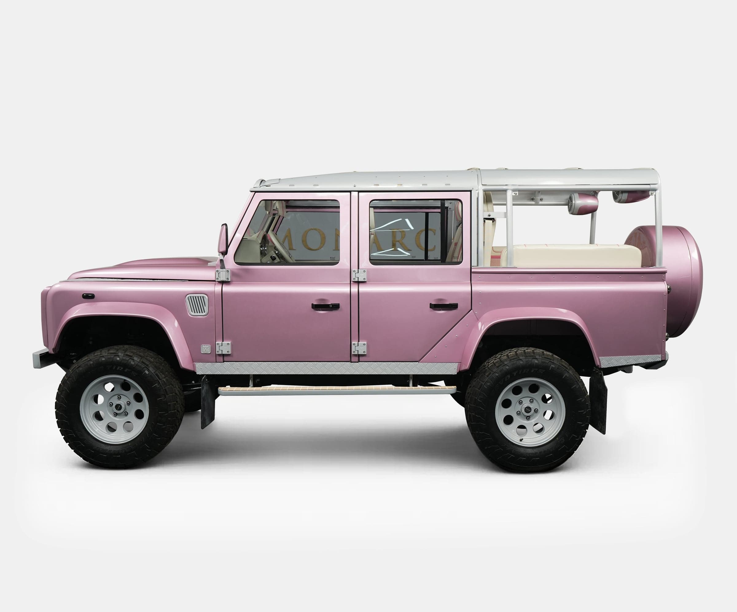 Side view of a custom pink Land Rover Defender showcasing luxury design and off-road capabilities