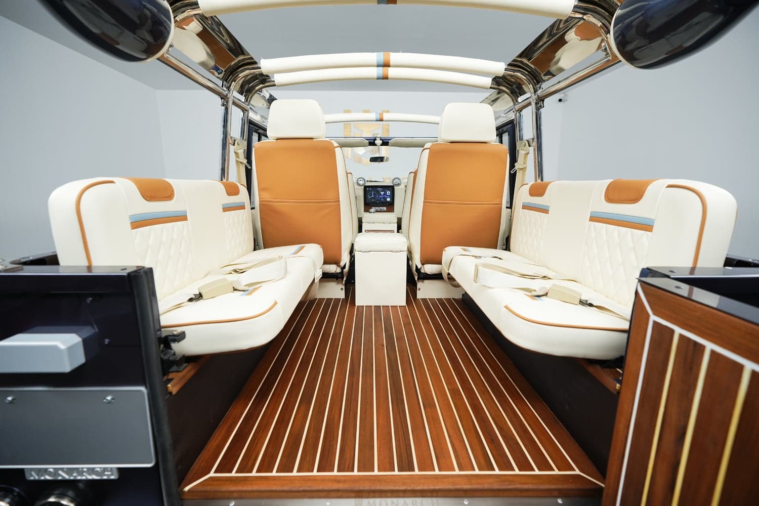 Interior view of a bespoke Land Rover Defender featuring premium leather seats and a wooden floor