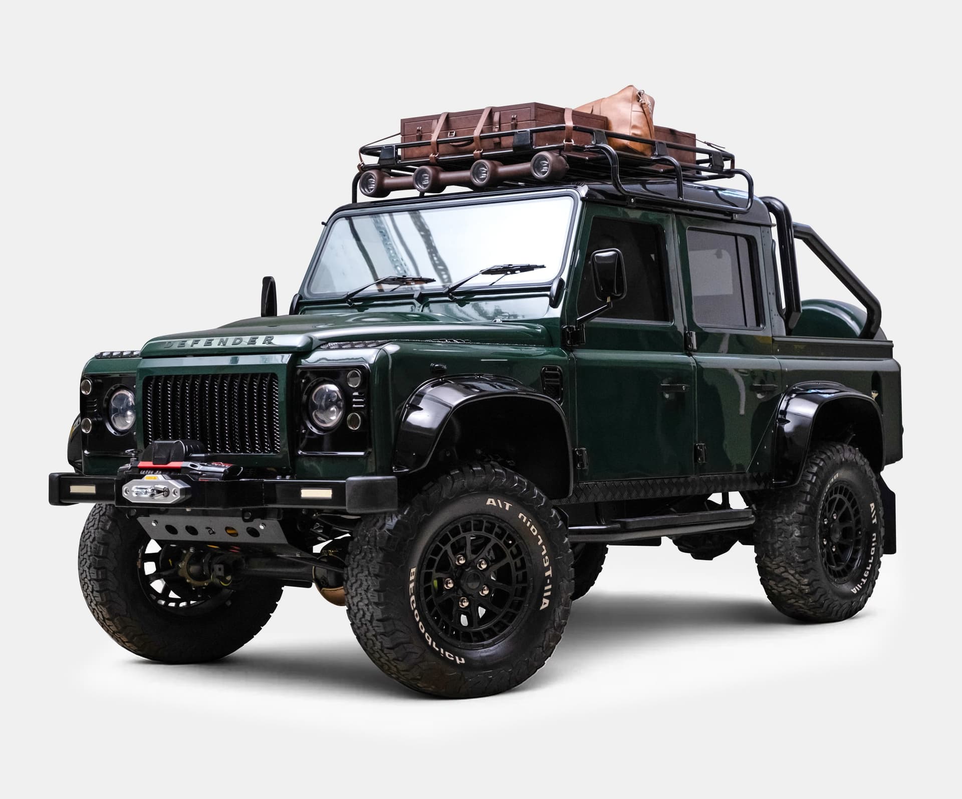 Custom Land Rover Defender in dark green with rooftop luggage