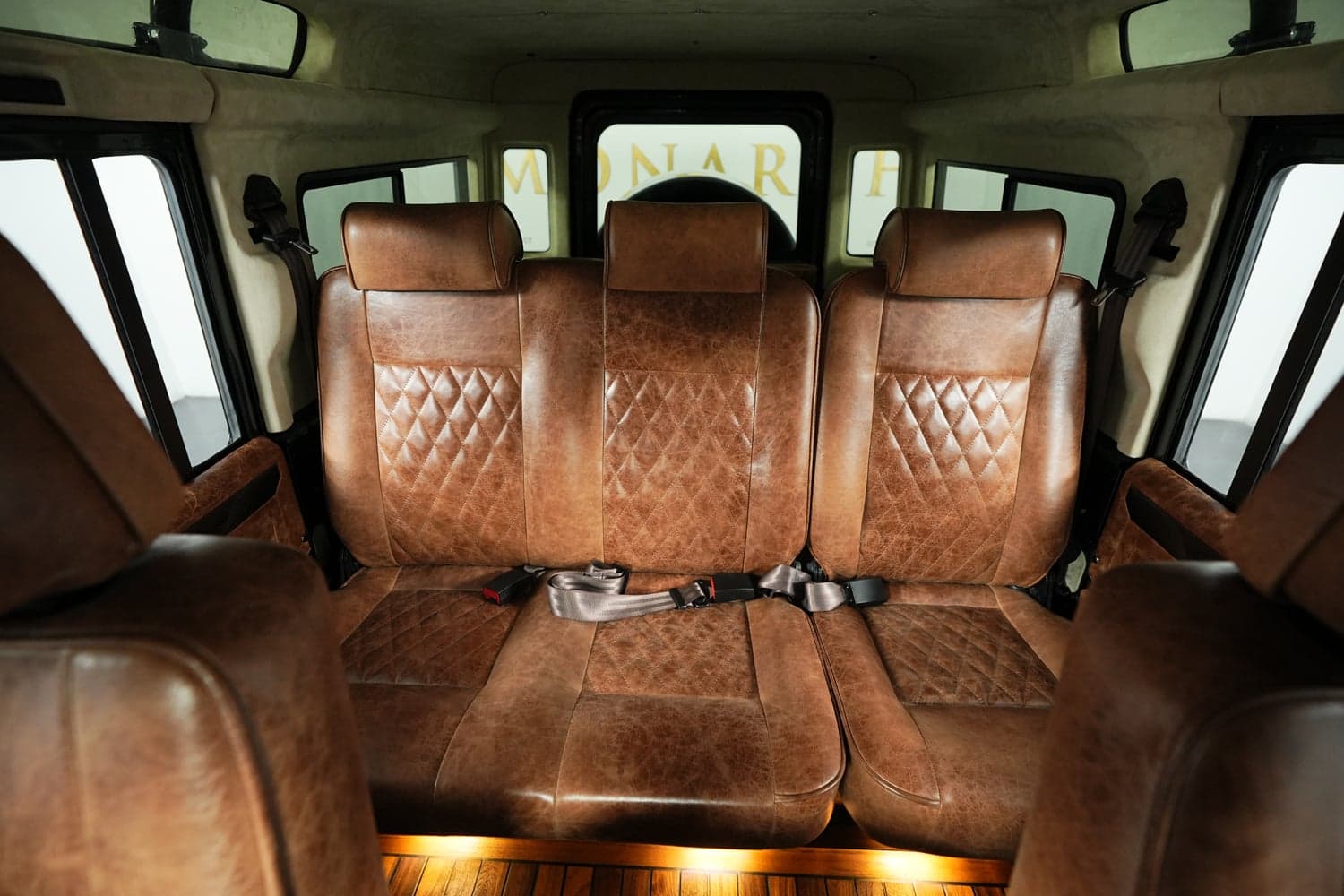 Luxurious brown leather rear seats with diamond stitching in a custom Land Rover Defender