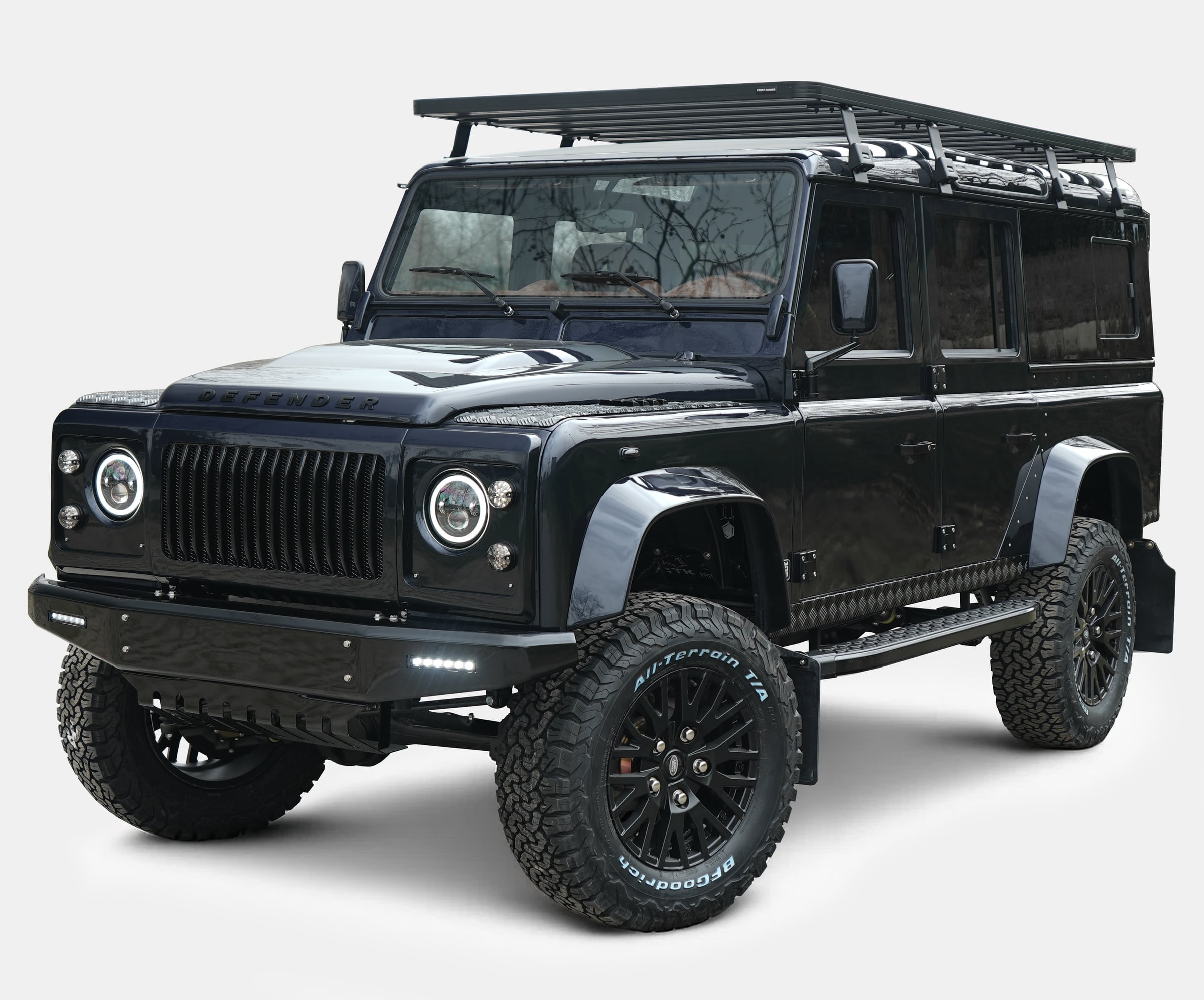 Custom black Land Rover Defender with off-road features and roof rack