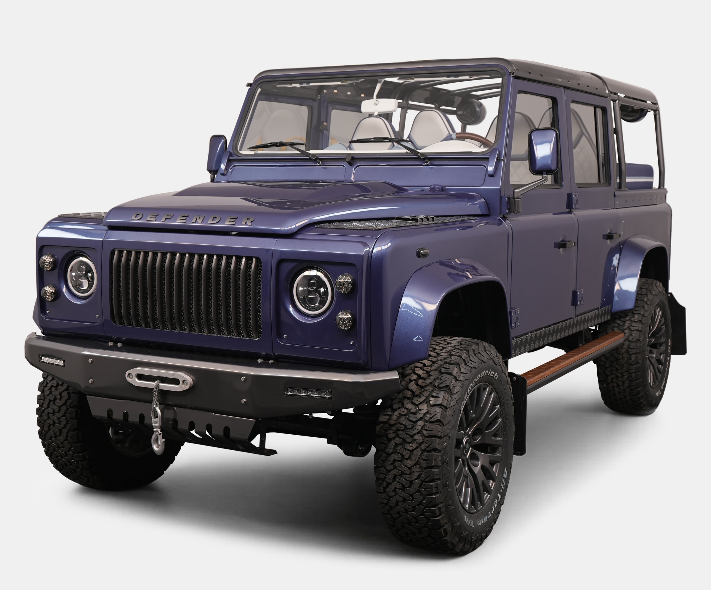 Custom Land Rover Defender in striking blue color with rugged tires and modern design features