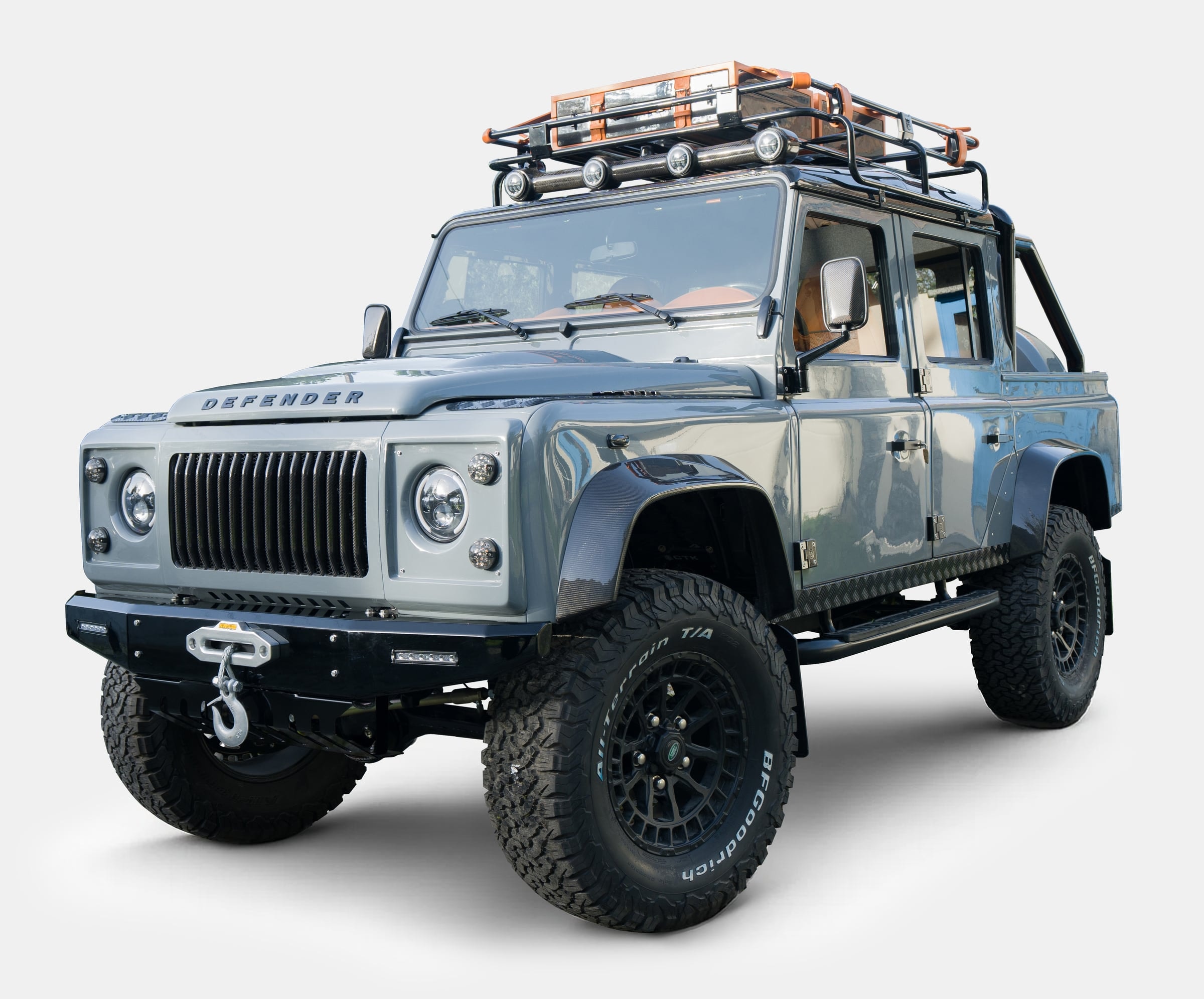 Front view of a customized Land Rover Defender with rugged styling and roof rack