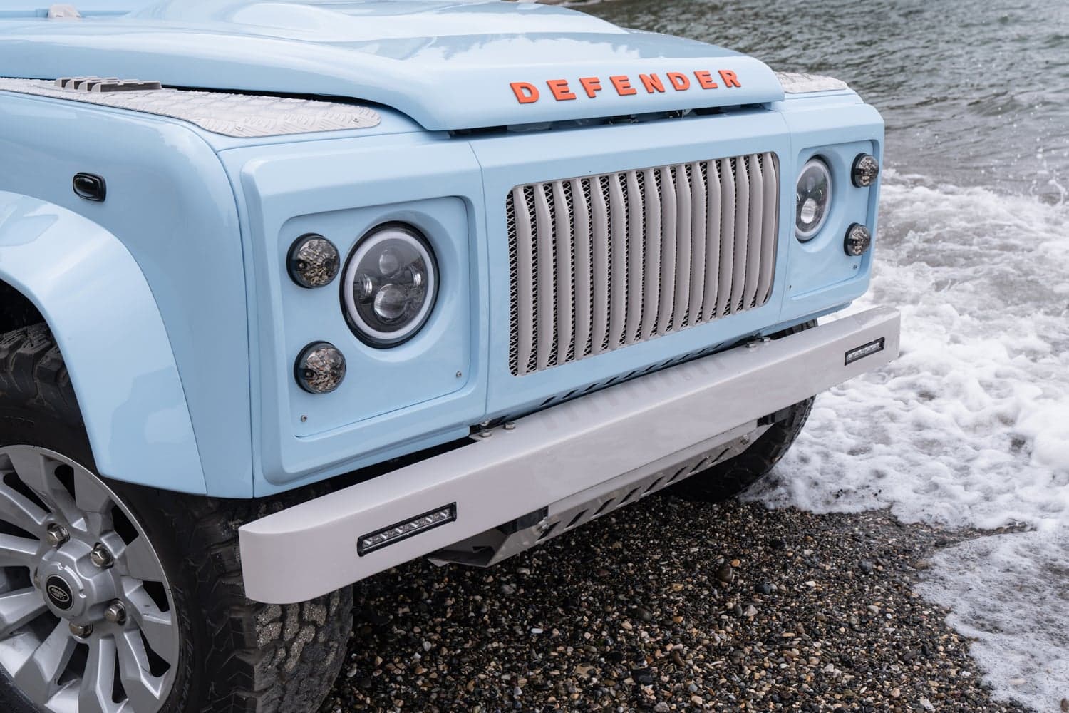 Front View: Custom Land Rover Defender Close-up of a bespoke Land Rover Defender in light blue with unique grille and headlights