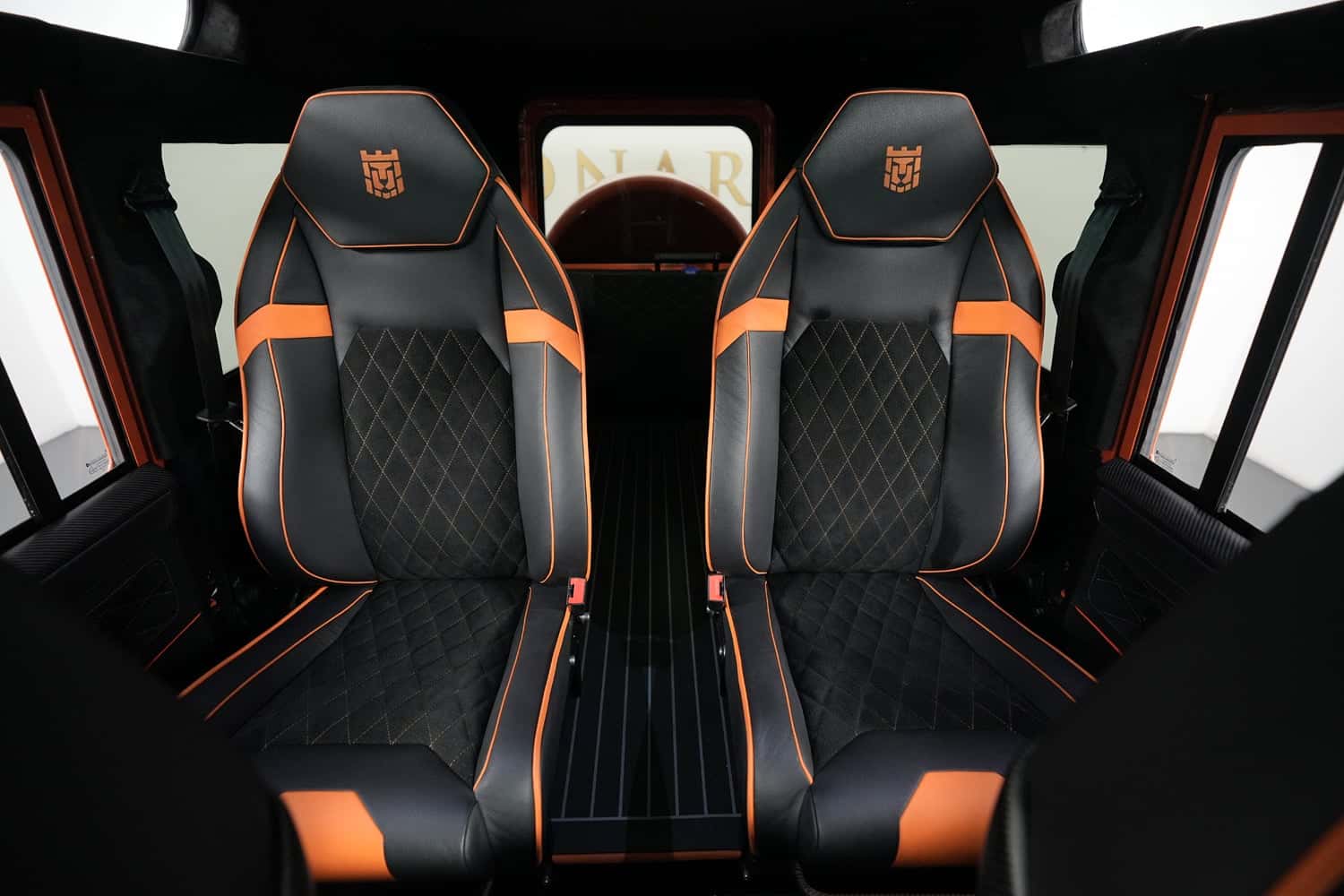 Interior Shot: Bespoke Seating Custom Land Rover Defender interior with luxury black and orange seats