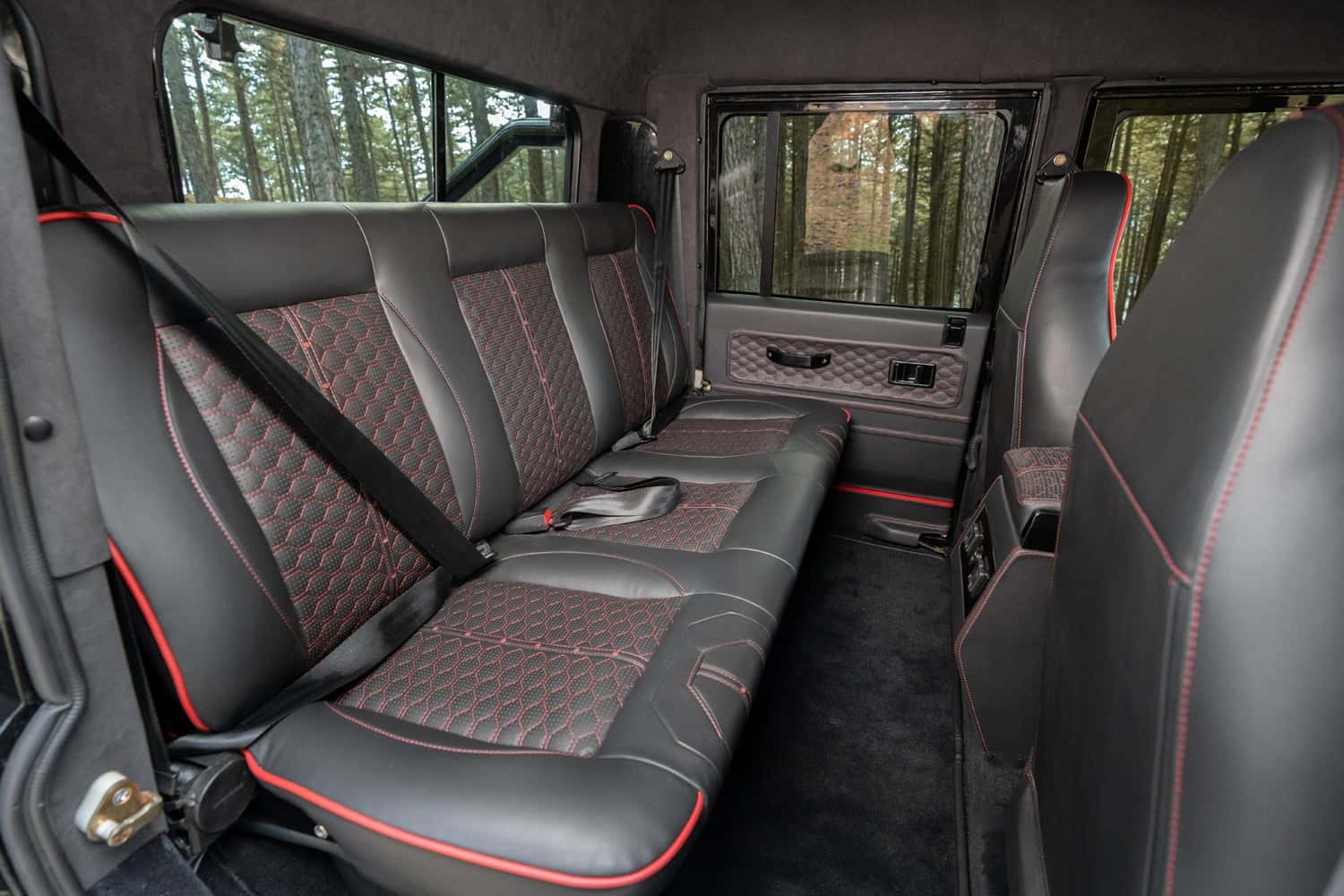 Interior Shot: Luxury Rear Seating Bespoke Land Rover Defender rear interior featuring premium leather seats with red stitching