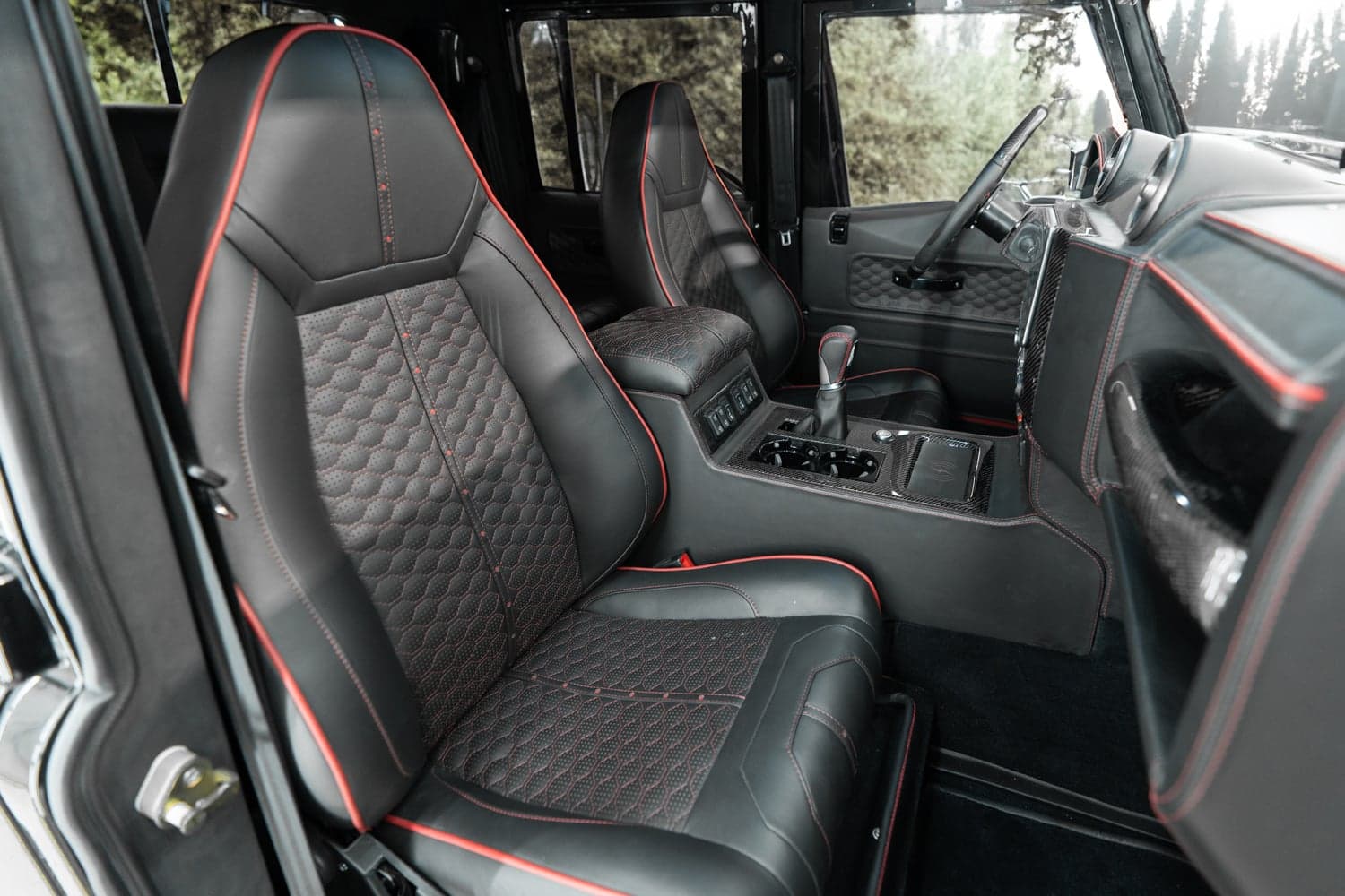 Interior Shot: Luxury Seating Bespoke Land Rover Defender interior featuring black leather seats with red stitching