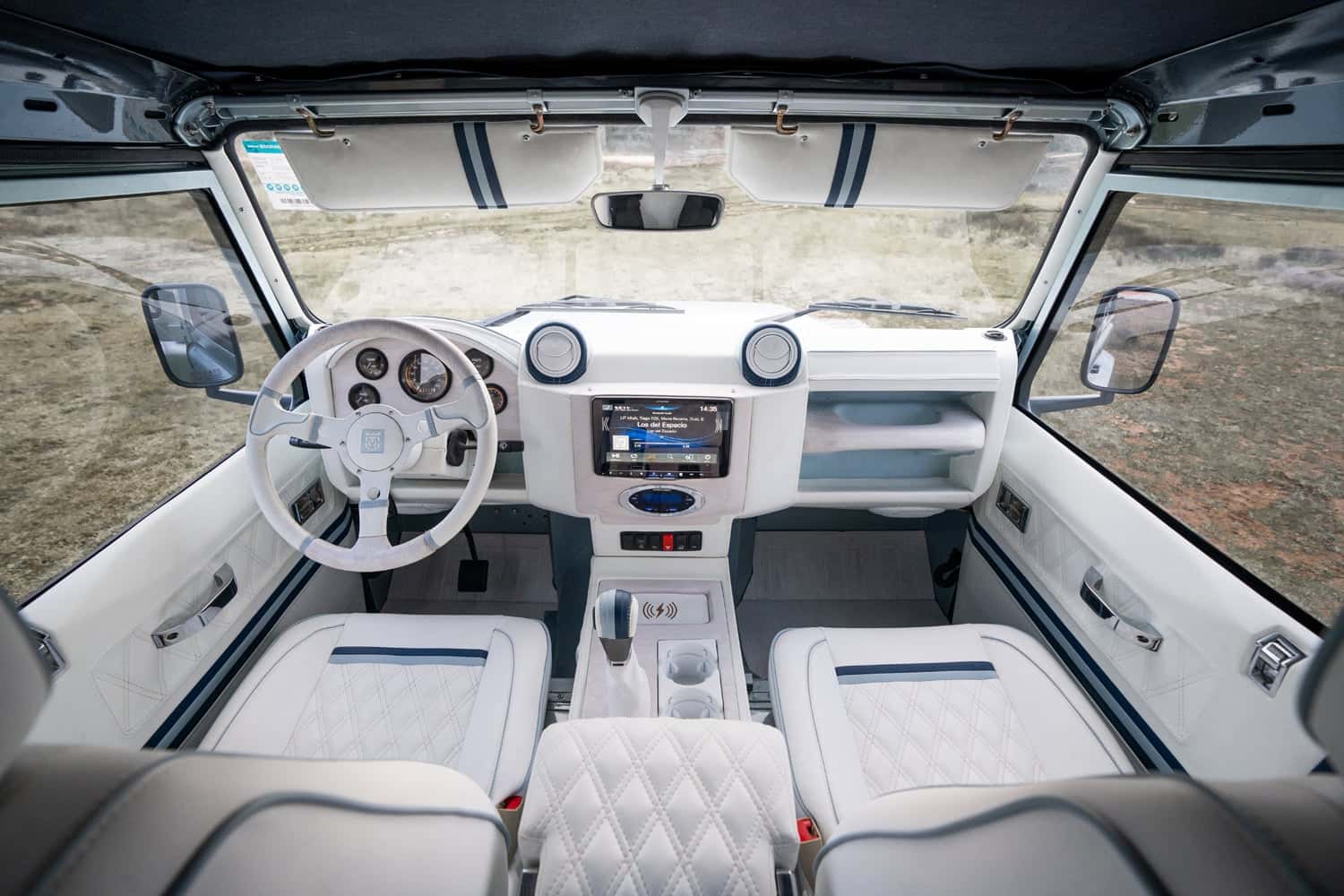 Interior Shot: Luxury Cabin Bespoke Land Rover Defender interior featuring white leather seats and modern dashboard