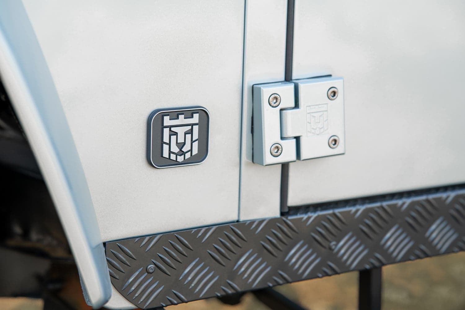 Detail Shot: Custom Badge and Hinge Close-up of a custom Land Rover Defender badge and hinge