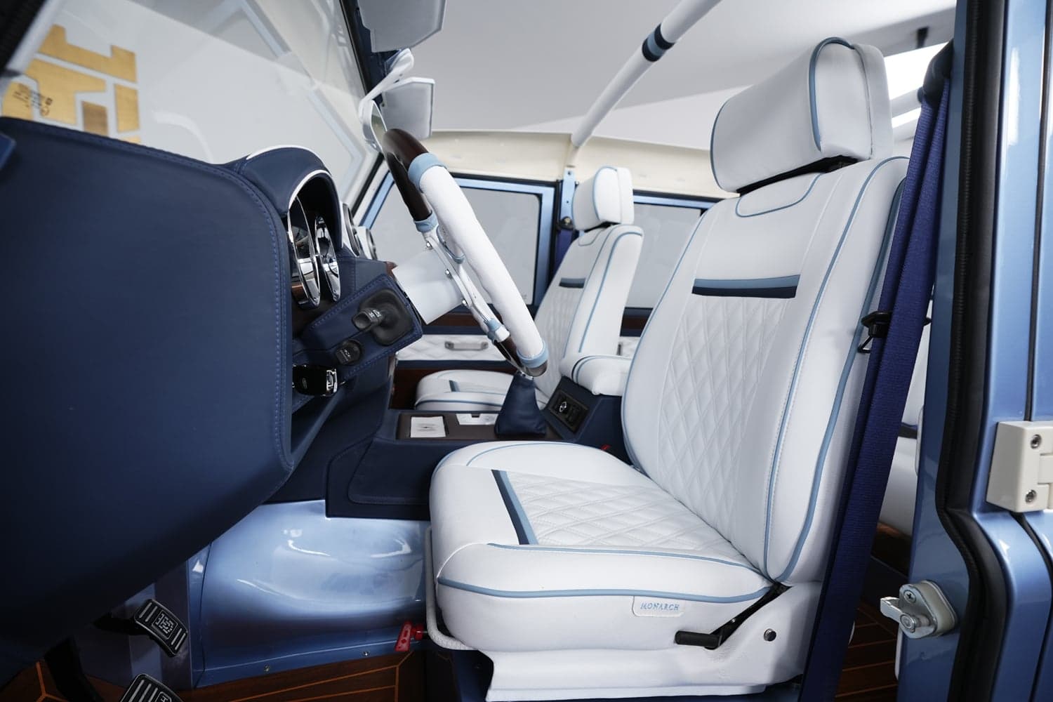 Interior Shot: Luxury Cabin Design Custom Land Rover Defender interior featuring premium white leather seats with blue accents