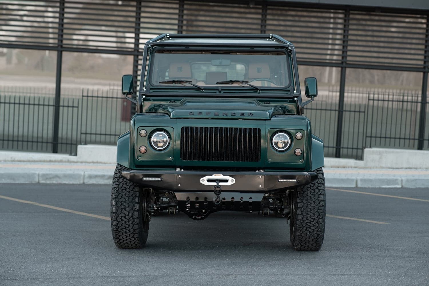 Front View: Bespoke Land Rover Defender Front view of a custom Land Rover Defender in green with distinctive grill and rugged tires