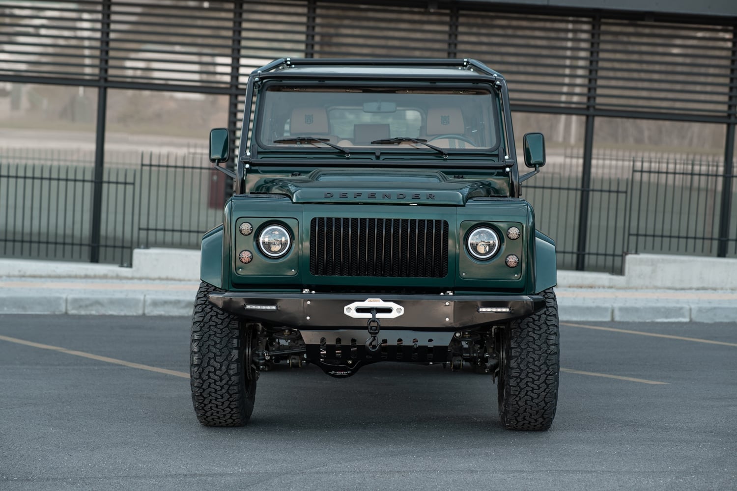 Front View: Bespoke Land Rover Defender Front view of a custom Land Rover Defender in green with distinctive grill and rugged tires