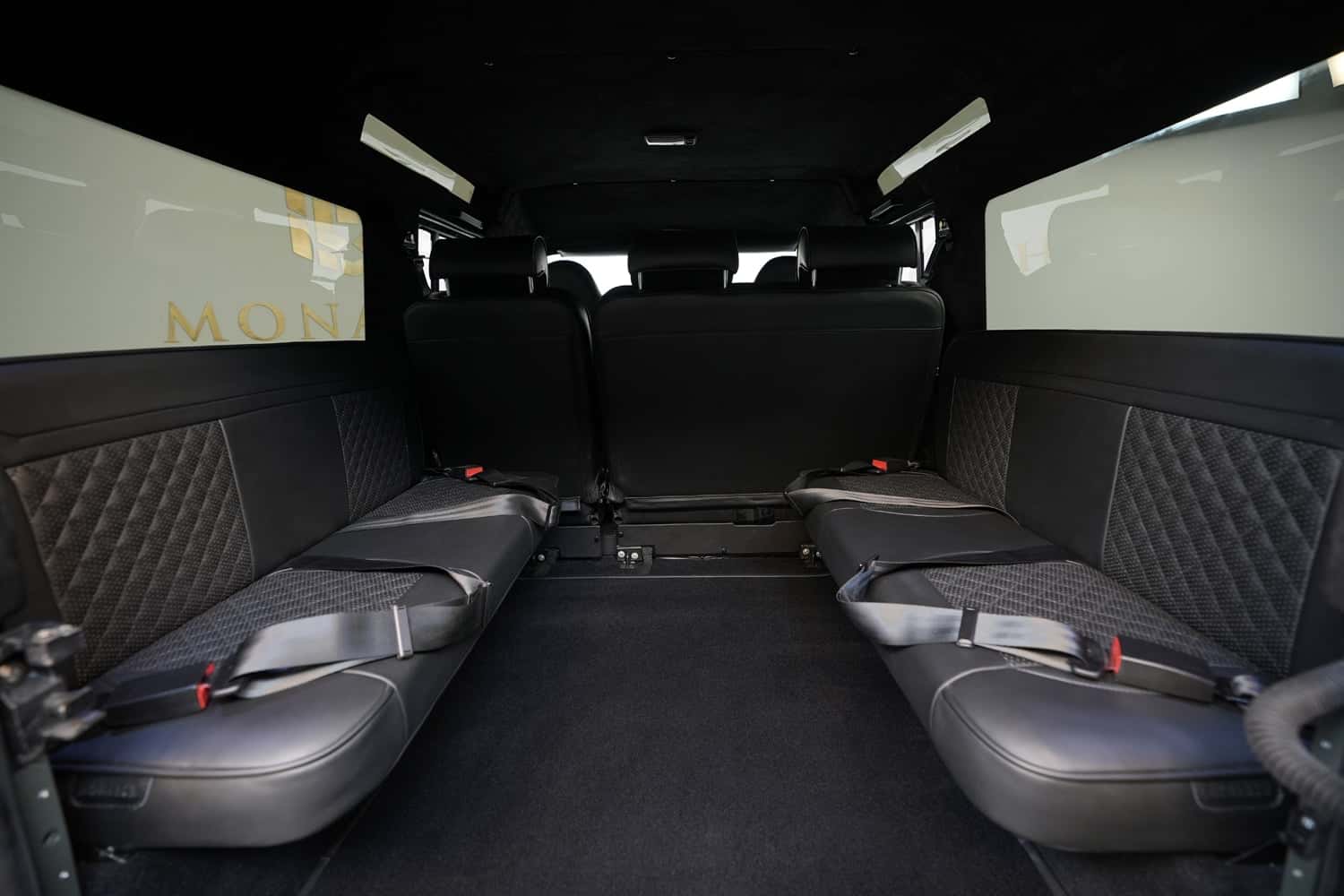 Interior Shot: Luxury Rear Seating Luxury rear seating of a bespoke Land Rover Defender with black leather and quilted detailing