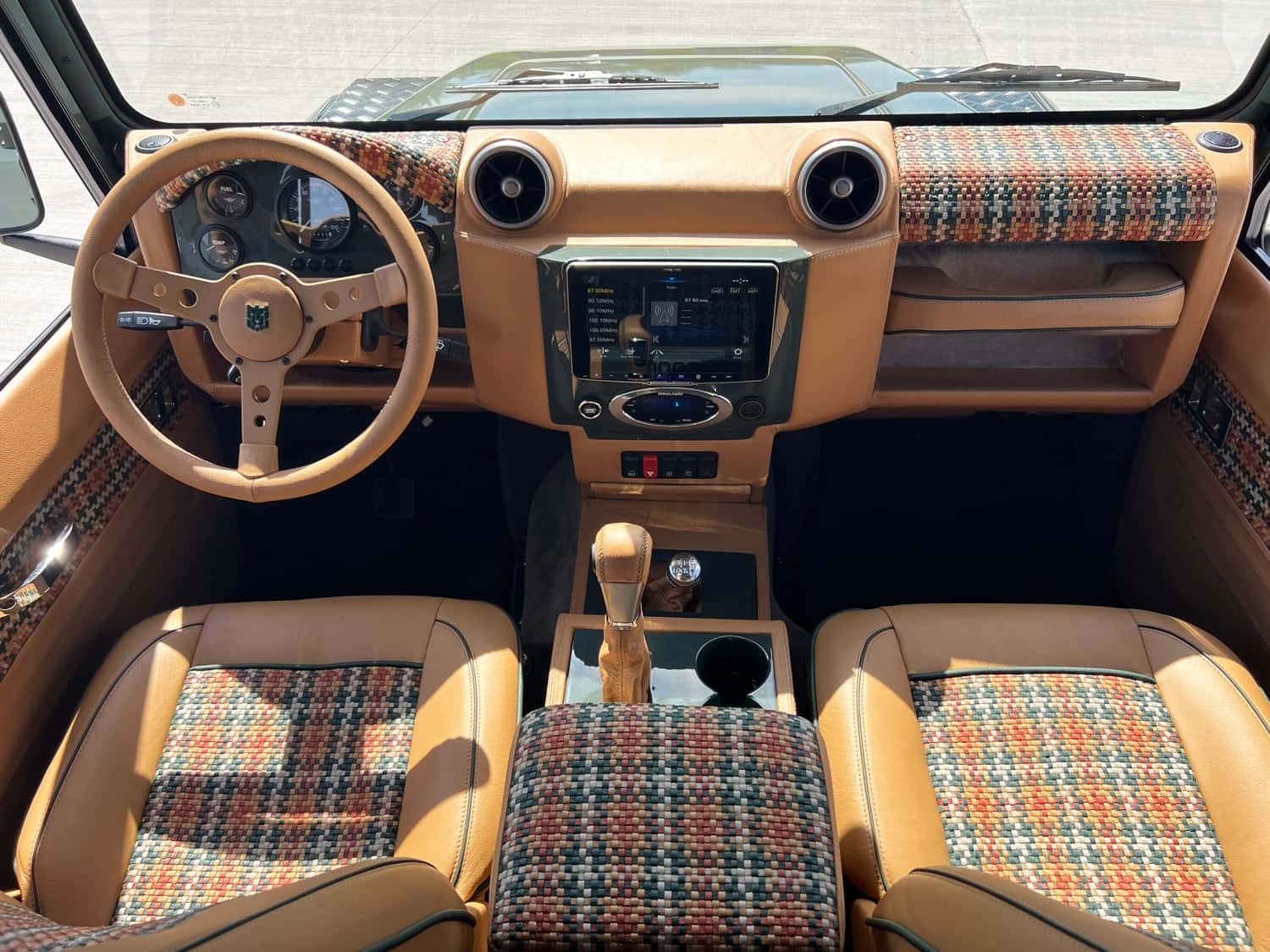 Interior Shot: Custom Land Rover Defender Cabin Luxury interior of a custom Land Rover Defender featuring premium materials and modern technology