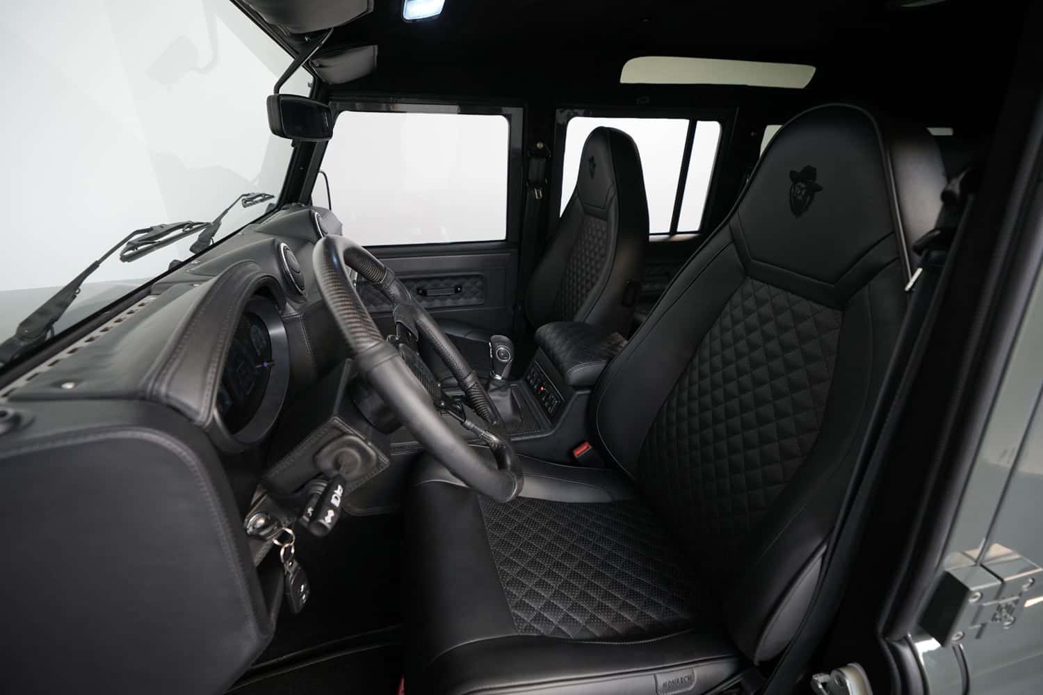 Interior Shot: Luxury Cabin Luxury interior of a custom Land Rover Defender with black leather seats and detailed stitching