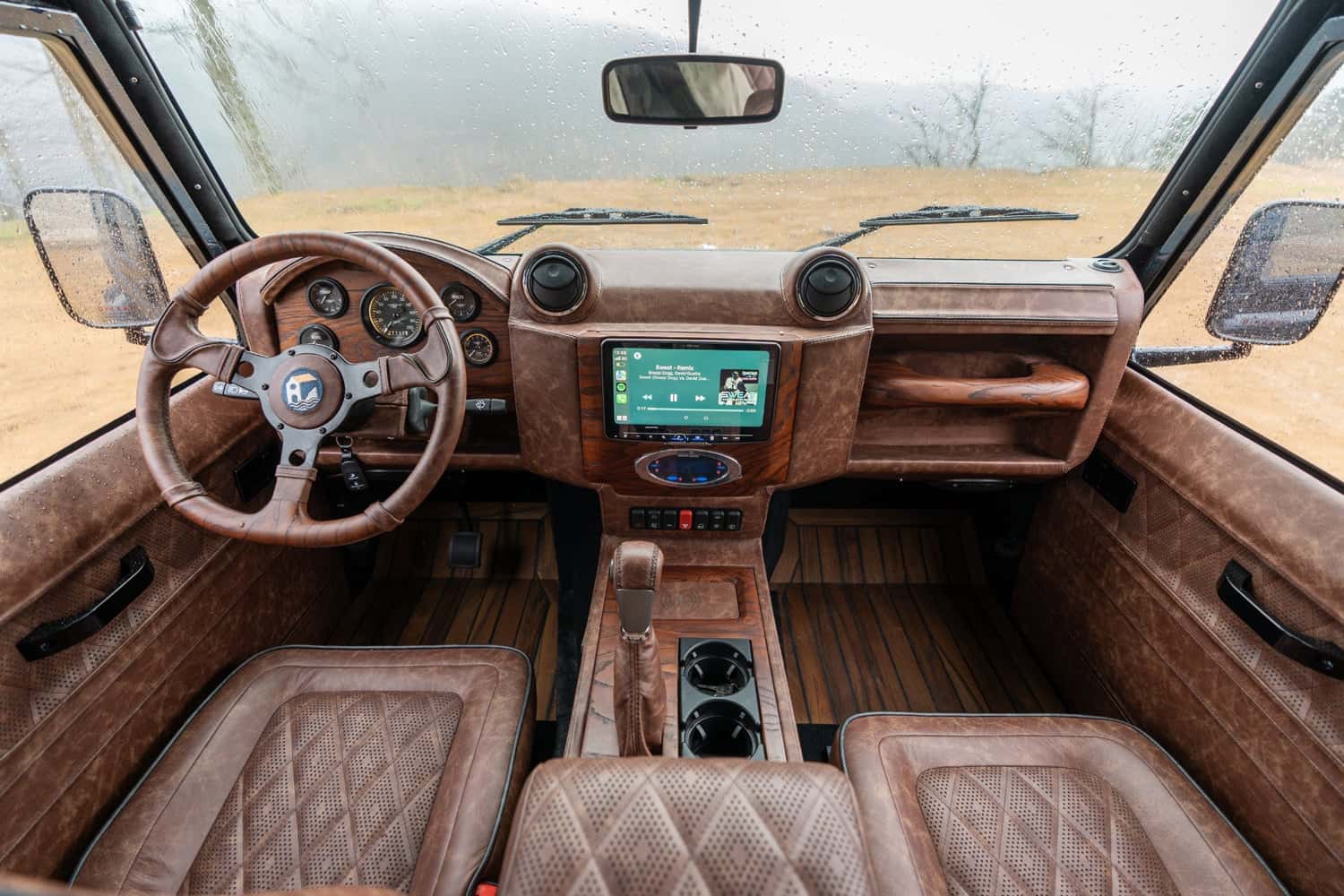 Interior Shot: Luxury Cabin Interior view of a bespoke Land Rover Defender with rich leather upholstery and modern technology