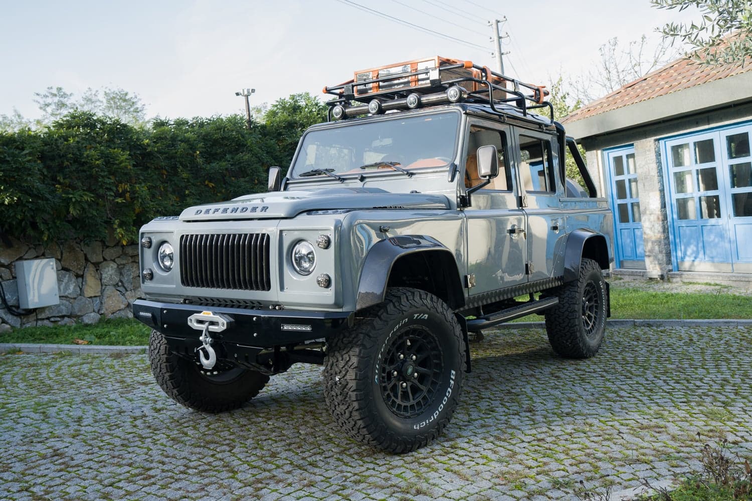 Front View: Bespoke Land Rover Defender Front view of a luxury custom Land Rover Defender with rugged tires and roof accessories