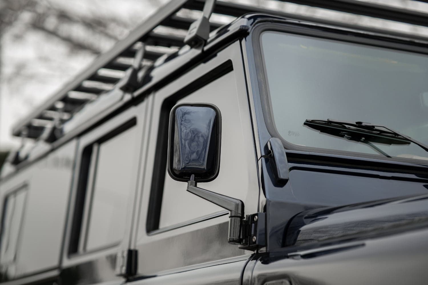 Detail Shot: Custom Mirror Design Close-up of a custom Land Rover Defender side mirror and window