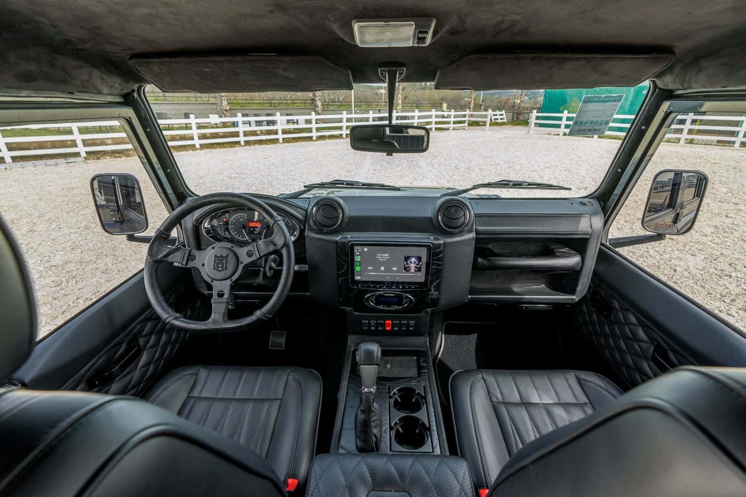 Interior Shot: Luxury Cabin Interior view of a bespoke Land Rover Defender showcasing premium black leather seats and modern dashboard features