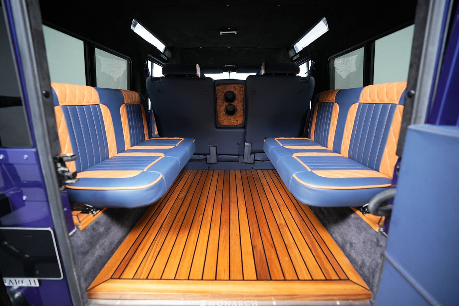 Interior Shot: Luxury Seating Bespoke Land Rover Defender interior with blue and orange seating and wood flooring