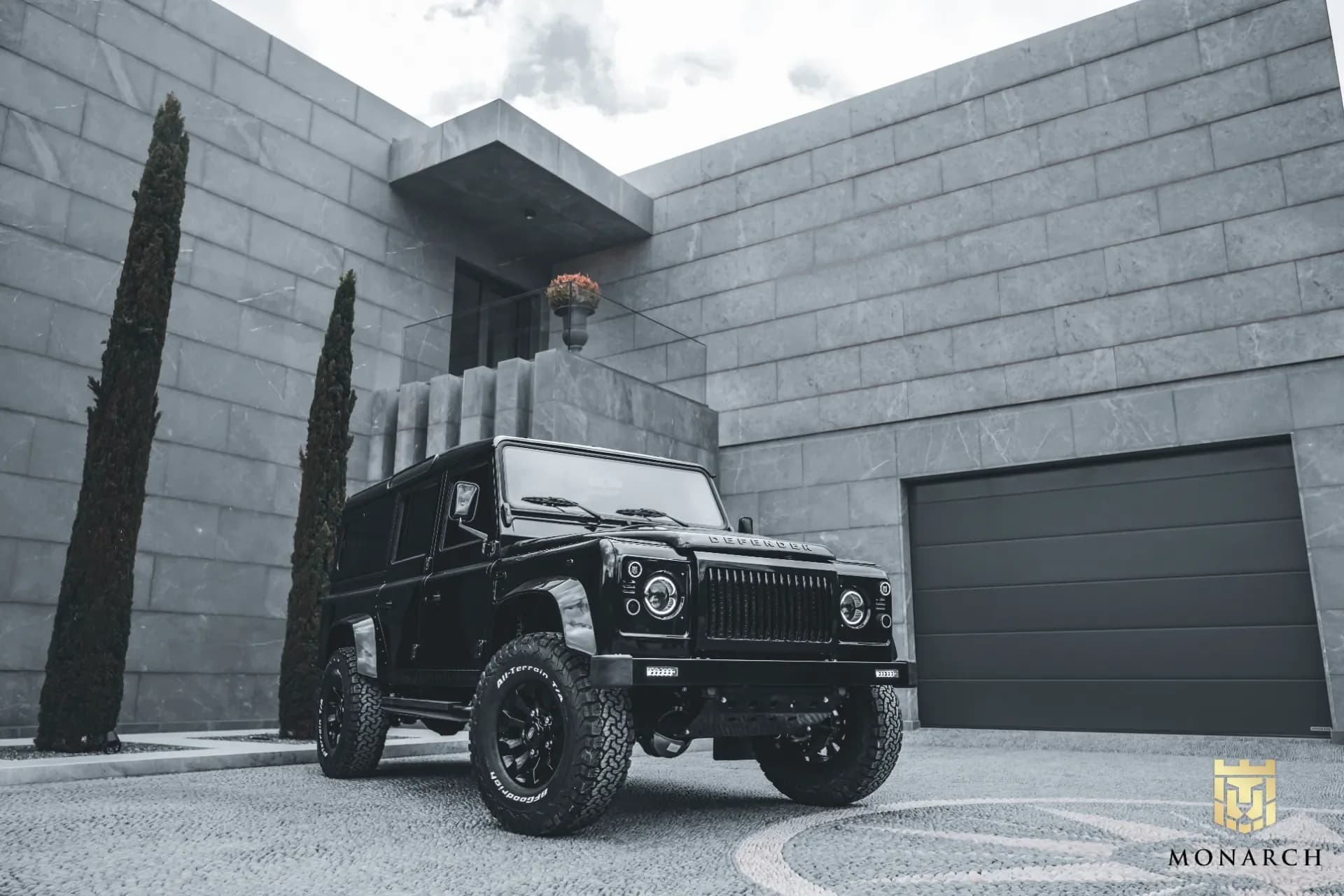 Side-by-side comparison showing a stripped Defender chassis on one side and a completed luxury restomod Defender on the other, illustrating the transformation of a ground-up build