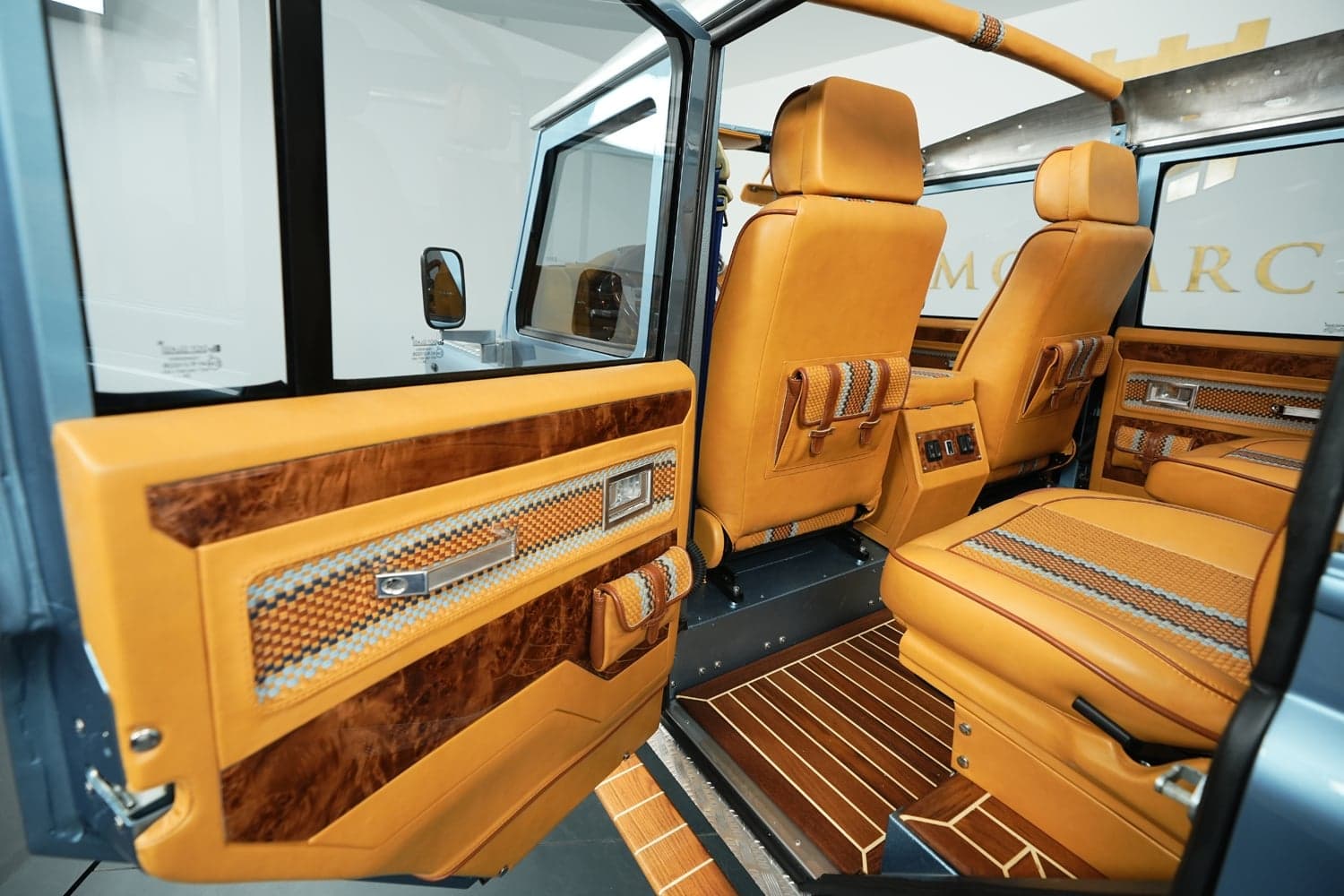 Close-up detail shot of hand-stitched leather with contrast stitching on a Defender door card, showing the texture and craftsmanship